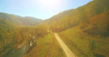 4K hava bakış açısı. Güneşli yaz sabahında, taze, hızlı dağ nehri üzerinde kayalıklarla alçak irtifa uçuşu. Yeşil çam ağaçları ve güneş ışınları. Saf soğuk su akıntısı.