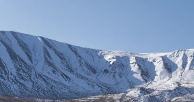 Güneş hareketinin 4K UHD zaman çizelgesi karlı dağın tepesinde kristal berrak gökyüzünde. Sonbahar otlağında sarı çimenler. Vahşi sonsuz doğa..