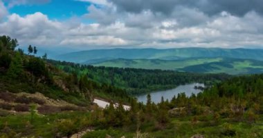 Dağ Gölü yaz ya da sonbahar zamanında zaman atlaması. Vahşi doğa ve kırsal alan. Hızlı bulutlar, yeşil çimenler ve dramatik gökyüzü. Motorlu doli kaydırma hareketi