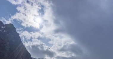 Yaz ya da sonbahar zamanı Dağ Vadisi 'ndeki destansı bulutların 4k UHD zaman çizelgesi. Vahşi sonsuz doğa ve kar fırtınası gökyüzü. Kar zirvesinde güneş ışınları. Hızlı hareket