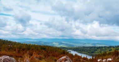 Dağ Gölü yaz ya da sonbahar zamanında zaman atlaması. Vahşi doğa ve kırsal alan. Hızlı bulutlar, yeşil çimenler ve dramatik gökyüzü. Motorlu doli kaydırma hareketi