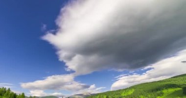 Yaz ya da sonbahar mevsiminde dağdaki çayır zaman atlaması. Vahşi doğa ve kırsal alan. Bulutların hareketi, yeşil çimenler ve güneş ışınları. Motorlu Panorama