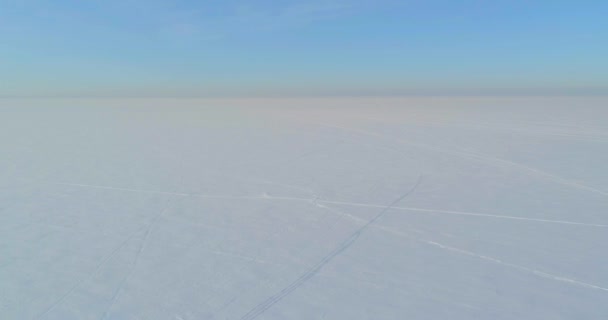 水平線上に霜雪 氷の川や太陽の光で覆われた木々 寒い冬の風景北極フィールドのドローンの空中ビュー 極端な低温の天候 — ストック動画