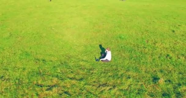 Высоты Птичьего Полета Низкоорбитальный Полет Вокруг Человека Сидящего Зеленой Траве — стоковое видео