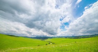 Yaz ya da sonbahar mevsiminde dağdaki çayır zaman atlaması. Vahşi doğa ve kırsal alan. Hızlı bulut hareketleri, yeşil çimenler ve güneş ışınları. Motorlu Panorama