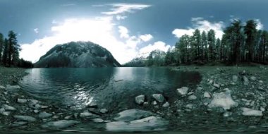 Kış mevsiminde 360 VR hızlandırılmış dağ gölü. Vahşi Sibirya doğası ve dağ vadisi. Çam ağaçlarından yeşil orman ve gökyüzünde hızlı bulutlar.