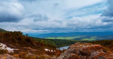 Dağ Gölü yaz ya da sonbahar zamanında zaman atlaması. Vahşi doğa ve kırsal alan. Hızlı bulutlar, yeşil çimenler ve dramatik gökyüzü. Motorlu doli kaydırma hareketi
