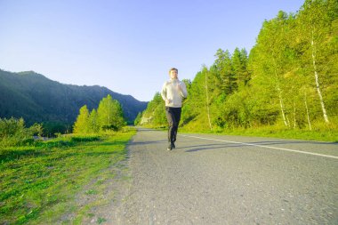 Koşan adam güzel bir yaz gününde şehir parkında koşuyor. Spor fitness modeli Kafkasya etnik köken eğitimi.