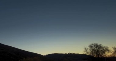 4k dağ çayırı yaz ya da sonbahar gündoğumu saatlerinde zaman atlaması. Vahşi doğa ve kırsal alan. Açık gökyüzü, ağaçlar, yeşil ve sarı çimenler, ufukta güneş ışığı. Motorlu kaydırma hareketi.