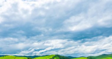 Yaz ya da sonbahar mevsiminde dağdaki çayır zaman atlaması. Vahşi doğa ve kırsal alan. Hızlı bulut hareketleri, yeşil çimenler ve güneş ışınları. Motorlu Panorama