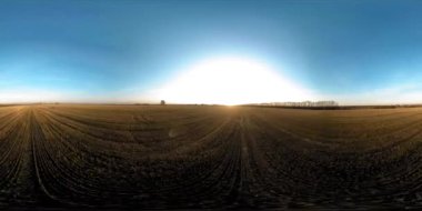 360 hava manzaralı. Güneşli bir sonbahar akşamında sonsuz yeşil tarlaları olan yaz manzarasının üzerinde alçak uçuş. Ufuktaki güneş ışınları. Hızlı yatay hareket. Tarım arazisi insansız hava aracı atışı. Dengeli