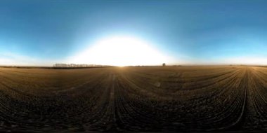 360 hava manzaralı. Güneşli bir sonbahar akşamında sonsuz yeşil tarlaları olan yaz manzarasının üzerinde alçak uçuş. Ufuktaki güneş ışınları. Hızlı yatay hareket. Tarım arazisi insansız hava aracı atışı. Dengeli