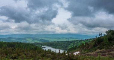 Dağ Gölü yaz ya da sonbahar zamanında zaman atlaması. Vahşi doğa ve kırsal alan. Hızlı bulutlar, yeşil çimenler ve dramatik gökyüzü. Motorlu doli kaydırma hareketi