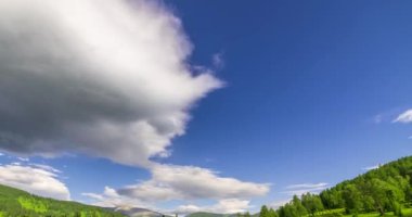 Yaz ya da sonbahar mevsiminde dağdaki çayır zaman atlaması. Vahşi doğa ve kırsal alan. Bulutların hareketi, yeşil çimenler ve güneş ışınları. Motorlu Panorama