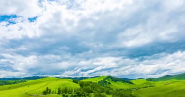 Yaz ya da sonbahar mevsiminde dağdaki çayır zaman atlaması. Vahşi doğa ve kırsal alan. Hızlı bulut hareketleri, yeşil çimenler ve güneş ışınları. Motorlu Panorama