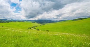 Yaz ya da sonbahar mevsiminde dağdaki çayır zaman atlaması. Vahşi doğa ve kırsal alan. Hızlı bulut hareketleri, yeşil çimenler ve güneş ışınları. Motorlu Panorama