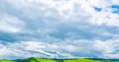 Yaz ya da sonbahar mevsiminde dağdaki çayır zaman atlaması. Vahşi doğa ve kırsal alan. Hızlı bulut hareketleri, yeşil çimenler ve güneş ışınları. Motorlu Panorama