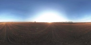 360 hava manzaralı. Güneşli bir sonbahar akşamında sonsuz yeşil tarlaları olan yaz manzarasının üzerinde alçak uçuş. Ufuktaki güneş ışınları. Hızlı yatay hareket. Tarım arazisi insansız hava aracı atışı. Dengeli