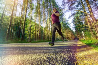 Koşan adam güzel bir yaz gününde şehir parkında koşuyor. Spor fitness modeli Kafkasya etnik köken eğitimi.