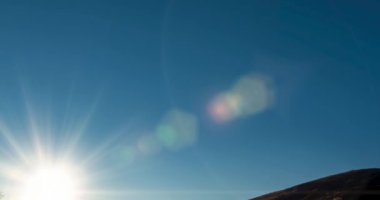 4k dağ çayırı yaz ya da sonbahar günbatımında zaman aşımına uğrar. Vahşi doğa ve kırsal alan. Açık gökyüzü, ağaçlar, yeşil ve sarı çimenler, ufukta güneş ışığı. Motorlu kaydırma hareketi.