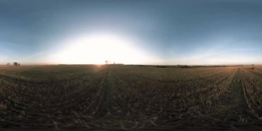 360 hava manzaralı. Güneşli bir sonbahar akşamında sonsuz yeşil tarlaları olan yaz manzarasının üzerinde alçak uçuş. Ufuktaki güneş ışınları. Hızlı yatay hareket. Tarım arazisi insansız hava aracı atışı. Dengeli