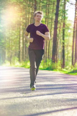 Koşan adam güzel bir yaz gününde şehir parkında koşuyor. Spor fitness modeli Kafkasya etnik köken eğitimi.