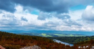 Dağ Gölü yaz ya da sonbahar zamanında zaman atlaması. Vahşi doğa ve kırsal alan. Hızlı bulutlar, yeşil çimenler ve dramatik gökyüzü. Motorlu doli kaydırma hareketi