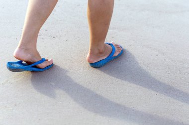legs of a human walking by the sea