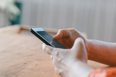 Kadın elinde cep telefonuyla oynuyor.