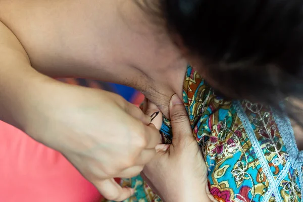 Woman's hand plucking armpit hair