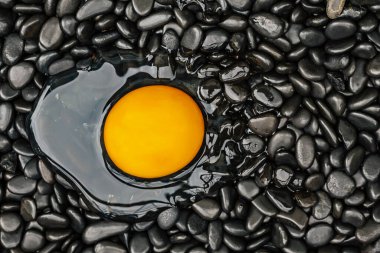 The yolk is placed on the black stone.