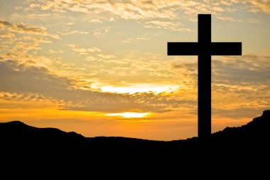 The cross has a backdrop of sunrise.
