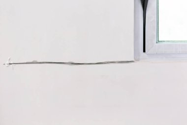 Evin duvarındaki çatlakları onarıyorum.