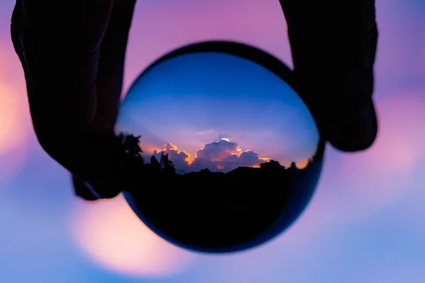 stock image Glass ball in hand reflecting sunlight
