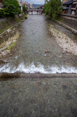 Tahta bir köprüden akan nehrin manzarası.