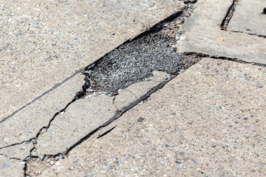 Çatlaklı ve delikli asfalt kaldırım hasarı. yol yüzeyi.
