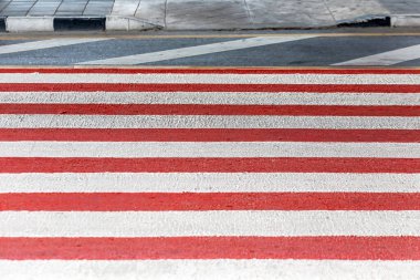 Asfalt kaldırımda kırmızı ve beyaz çizgili zebra şeritleri