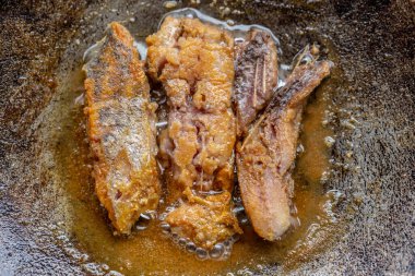 Tavada yağlı kızarmış balık.