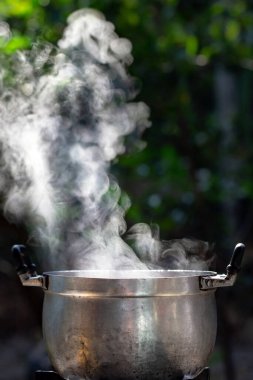 Dumanın arka planındaki tavada sıcak kaynar..