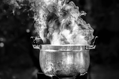 Arkasında ateş olan bir tencere.