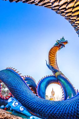 Ejderha heykeli tapınağın çatısında duruyor, mavi gökyüzü arka planında.