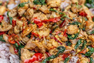 Baharatlı köri soslu kızarmış tavuk ve fesleğen yaprağı.