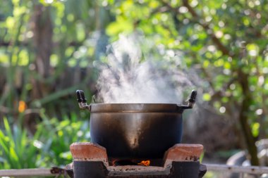 Bahçedeki ateşte demlik pişiriyorum.