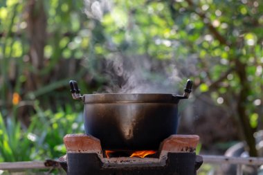 Doğada yanan bir ateşle bir kazanda yemek pişirmek.