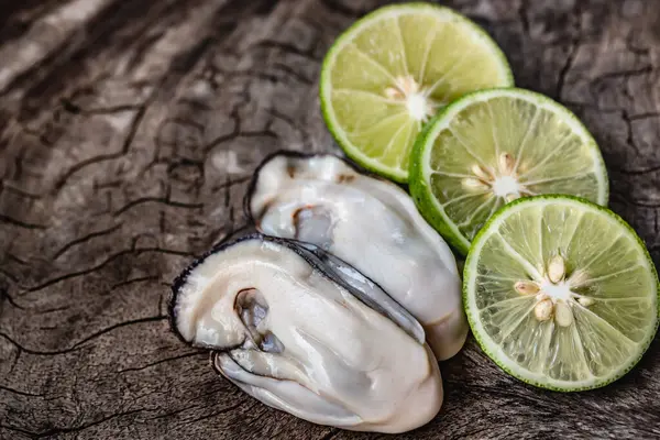 Tahta bir masada yeşil limon ve limon.