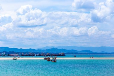 Tekneleri ve denizleri olan tropik bir sahil.
