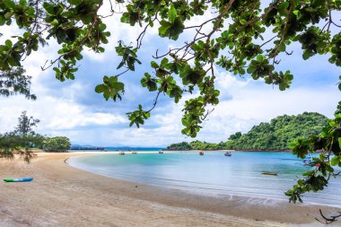 Mavi gökyüzü ve denizi olan tropik plaj.