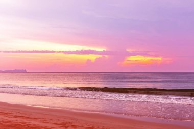 Güzel tropikal gün batımı, palmiye ağaçları ve bulutlu deniz.