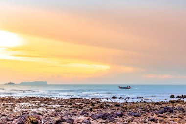 Sahilde gün batımı renkli bulutlarla.