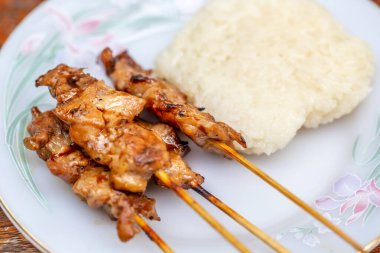 Tavuklu ve pilavlı kızarmış çubuklu beyaz tabak.